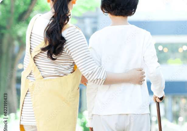 杖をつくよ女性を介護する様子